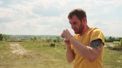 Man Practicing Boxing Moves in Scenic Park on a Sunny Afternoon