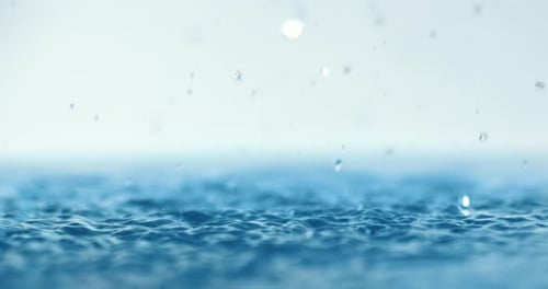 Water Droplets Falling on Rippling Water Surface