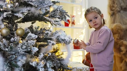 Child Decorating Christmas Tree with Ornaments at Home