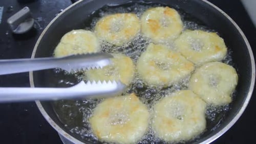 A kuih keria está sendo frita com óleo de cozinha em uma panela quente. É um bolo malaio tradicional. Feito de