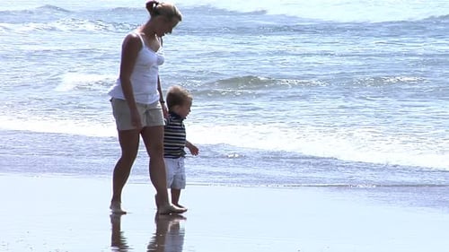 Loving mother and young son enjoying carefree playtime on a sunny beach vacation