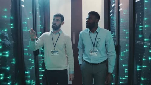 Two Men Discuss and Analyze a Server in a Modern Server Room