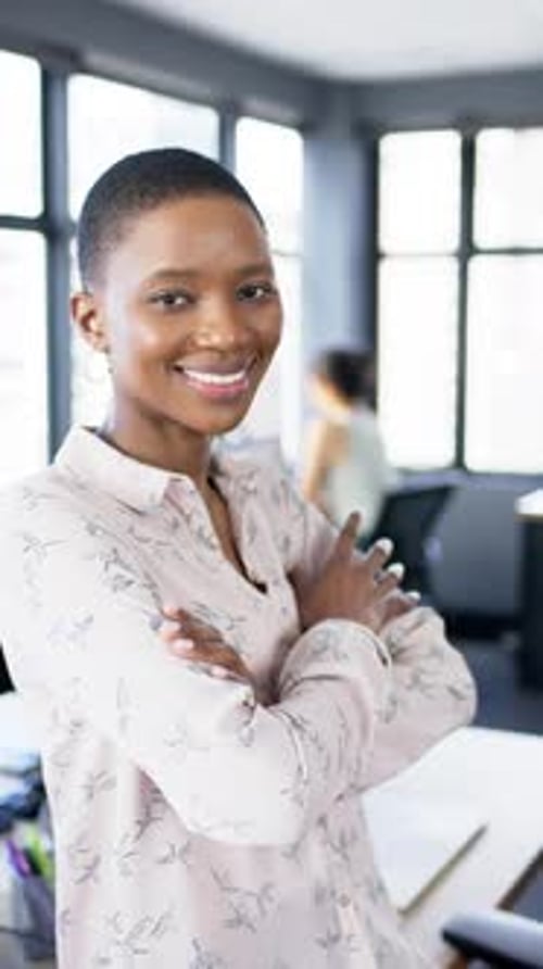 Vertical video of smiling african american businesswoman in office, slow motion, copy space