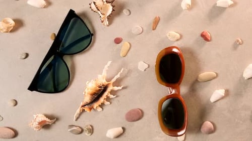 Sunglasses and seashell lie on beach sand. Travel summer accessories, Travel planning concept