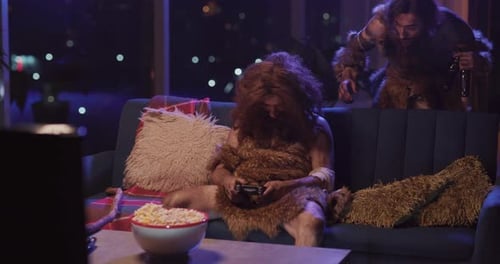 Un ancêtre humain drôle s'endort sur le canapé dans un appartement moderne, son meilleur ami Savage revient