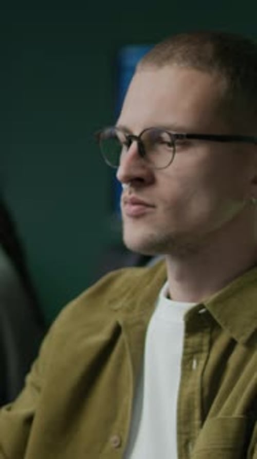 Vertikale Darstellung eines jungen männlichen Programmierers, der nachts im Büro arbeitet