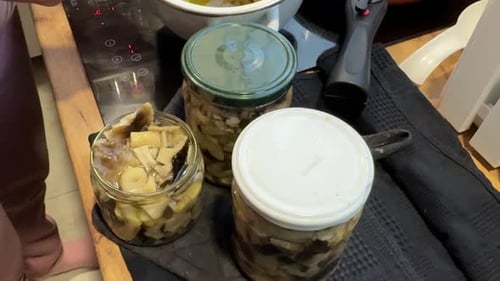 Preservation Of Mushrooms. A Woman Is Putting Pickled Mushrooms Into Jars.