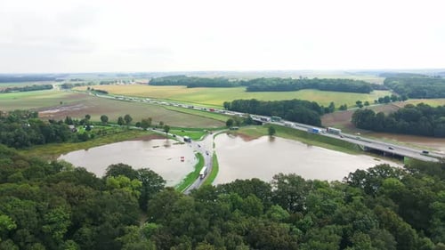 Flooded Rural Road Near Highway with Traffic Jam