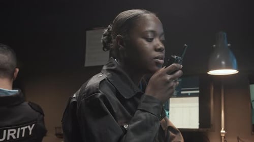 Woman Using Walkie-Talkie in Security Control Room