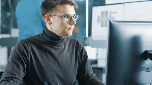 Junger männlicher Wirtschaftsingenieur arbeitet an einem PC. Hübscher kluger Mann in der Bright Moder