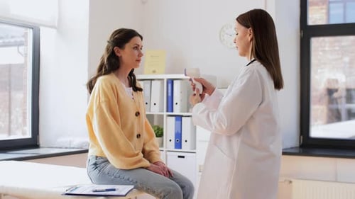 Doctor Examines Patient Temperature with Thermometer