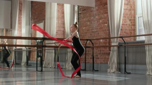 Child Performing Rhythmic Gymnastics with Red Ribbon