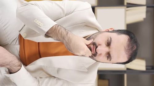 Man Rubbing Face While Sitting on Couch