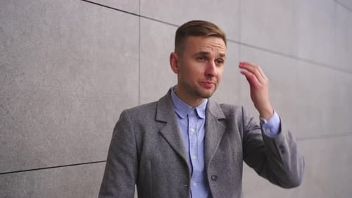 Man Smiles, Adjusts Cuffs in an Urban Setting