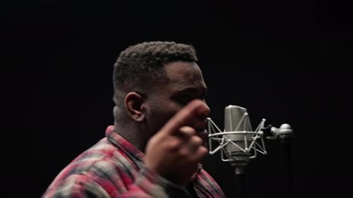 Young Adult Singing Into Microphone in Recording Studio