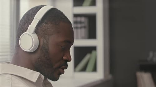 Black Man in Wireless Headphones Working at Home Office