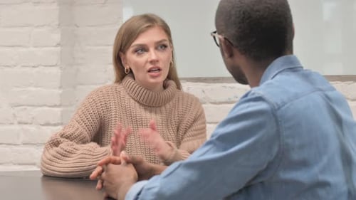 Jeune femme décontractée parlant avec un collègue africain