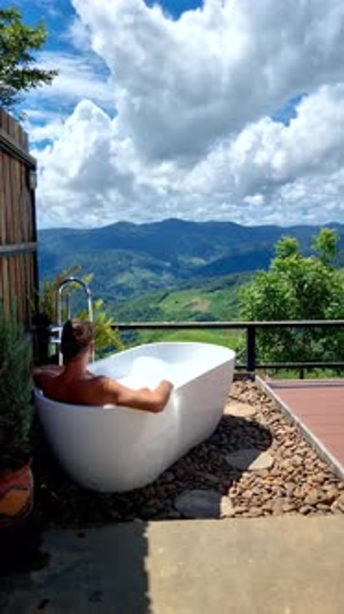 Homens e mulheres em uma banheira com vista para as montanhas de Chiang Rai, norte da Tailândia