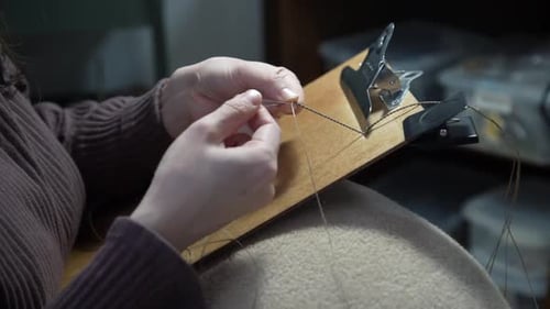 Hands Crafting Macrame Knot on Board Indoors