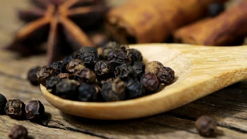 Whole Black Peppercorns Fill Small Wooden Spoon