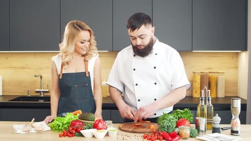Junge Frau und Mann bereiten Essen zu und veranstalten eine Kochshow, die Blogger aus Kitchen Healthy streamen