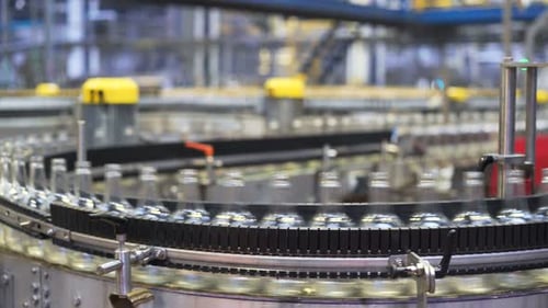 Glass bottles move on conveyor belt at an automated alcoholic beverage plant