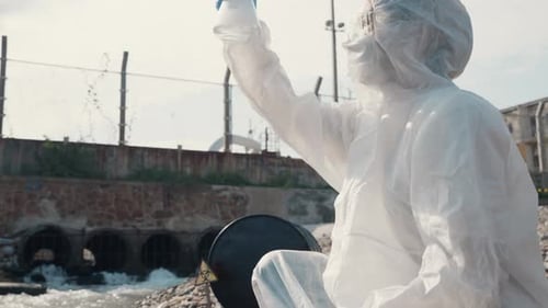 Ecologist Sampling Water Toxic Chemicals From River with Test Tube Glass and Have White Smoke