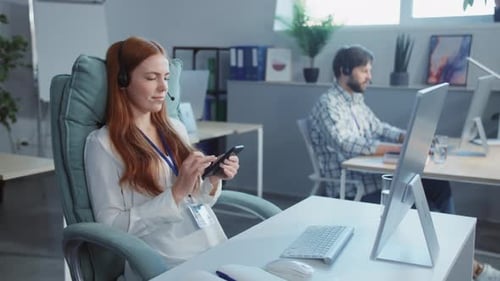 Businesswoman Using Phone in Modern Office with Colleague