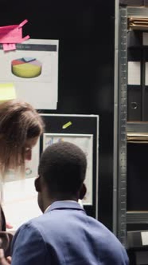 Colleagues Collaborate in Office Reviewing Charts