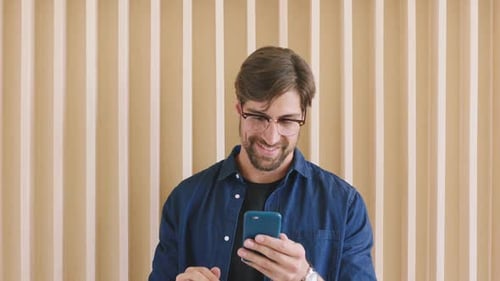 Man Uses Mobile Phone With Focus Indoors