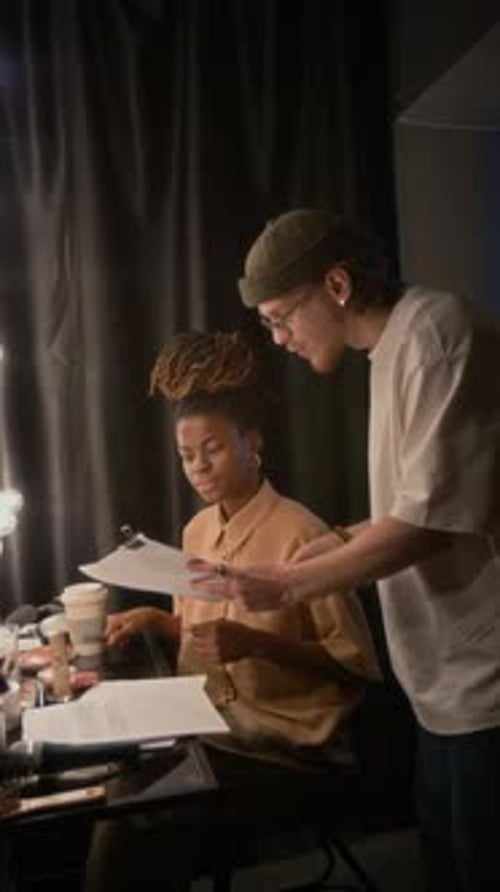 Two Colleagues Discussing Performance Script in Dressing Room