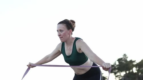 Woman Exercising with Resistance Band Outdoors
