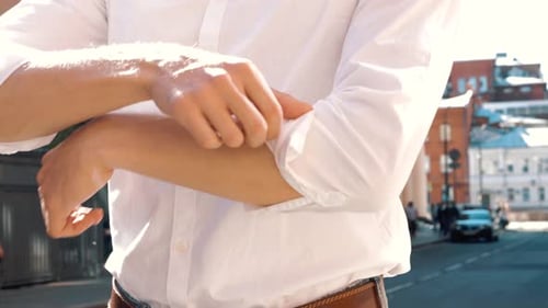 Young Adult Rolling Up Sleeves in the City