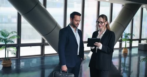 Business Professionals Discussing Project in Modern Office Lobby