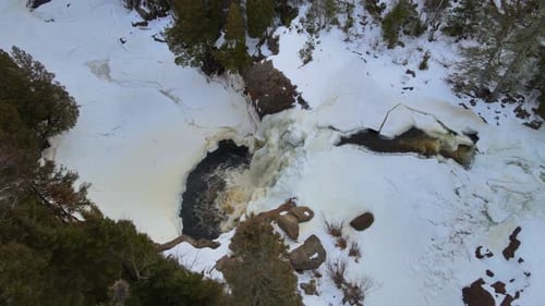 Amazing high view of frozen waterfall middle in forest of North Minnesota