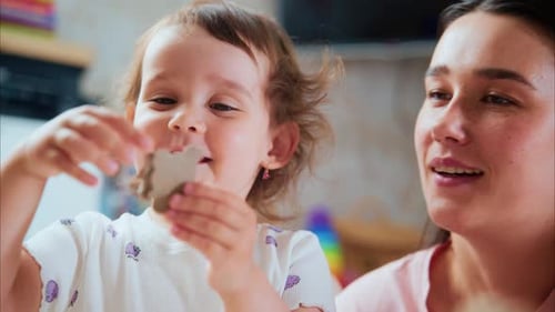 Child Plays with Clay with Smiling Adult