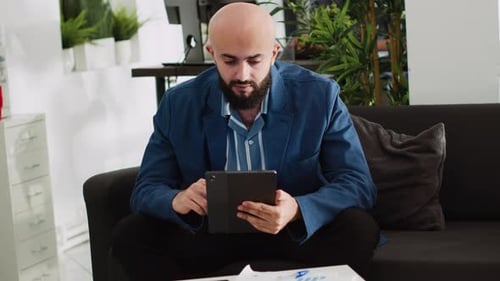 Man Working on Tablet in Modern Office Setting