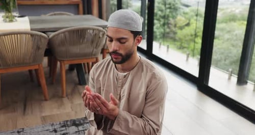 Man Kneeling in Prayer Inside a Home