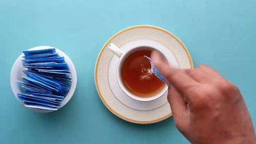 Pouring Sugar Substitute Sweetener in a Cup of Tea