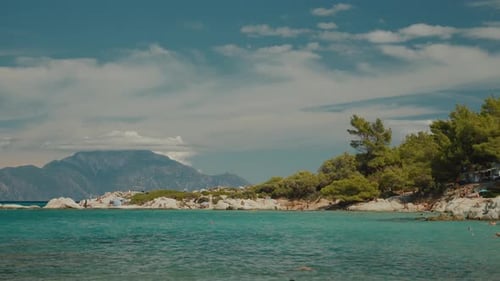 Tourists sunbathing and swimming, enjoying clear turquoise waters