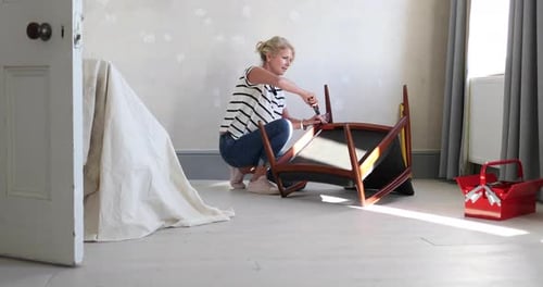 Mature female repairing an old chair