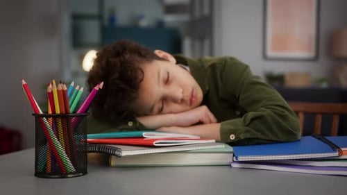 African American Little Son Boy Kid Child Sad Upset Frustrated Fatigued Exhausted Lying on Books at