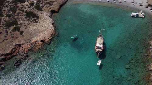 Sail boat anchored in a serene bay surrounded by pristine beaches and turquoise green water . Pictur