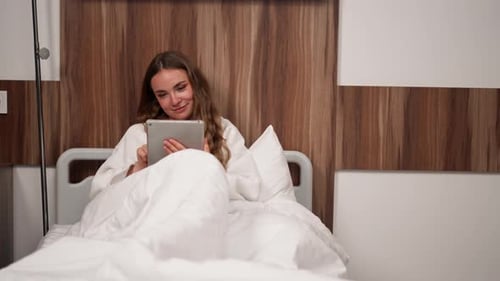 in Modern Clinic in a Bright VIP Room a Young Girl in a White Coat Lies on a Bed Before an Operation