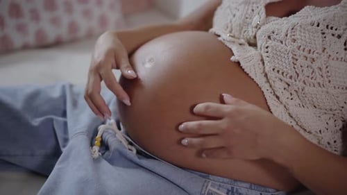Femme méconnaissable caressant le ventre à un stade avancé de la grossesse gros plan de la femme enceinte