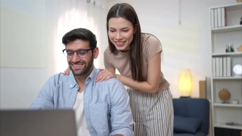Smiling Couple Working Together on Laptop at Home