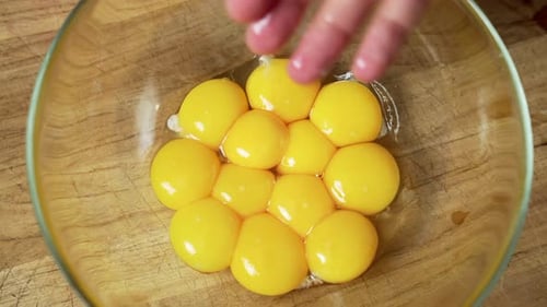 Close up: The Chef is Separating the Egg Yolks from the Whites with his hands.
