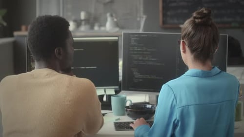 Colleagues Discussing Programming Code on Computer Monitor