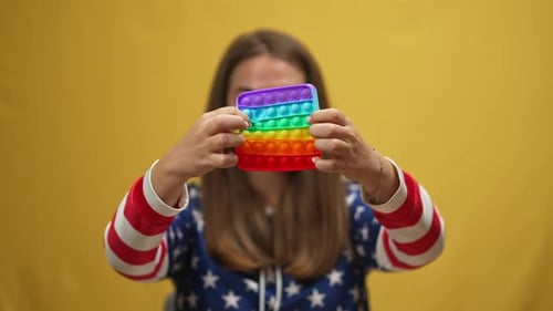 Closeup Multicolored Fidget Toy with Hands of Blurred Young Woman Popping Dimples in Slow Motion