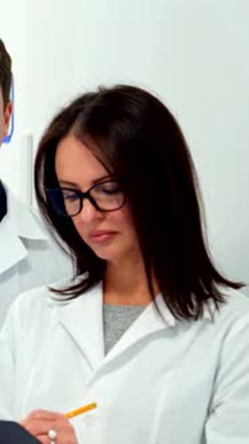 Focused Doctors Taking Notes in Hospital Setting